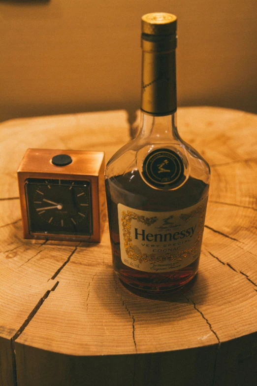 the bottle of henness bourbon is next to a clock