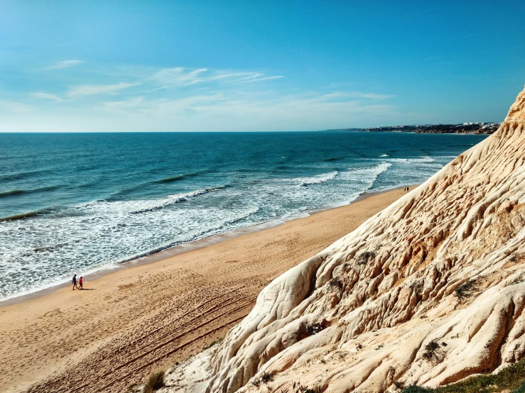 a lone surfer riding his board on the edge of a large cliff