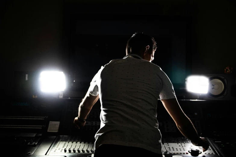 a person standing in a dimly lit recording studio