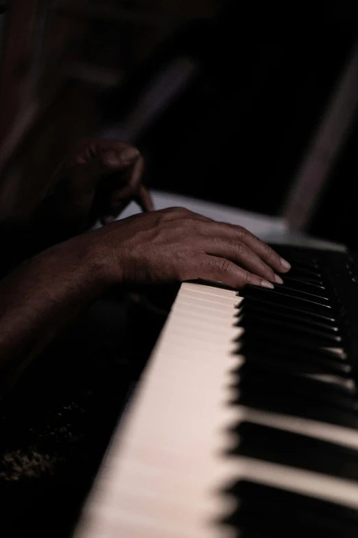 the person is playing the piano keyboard with one hand