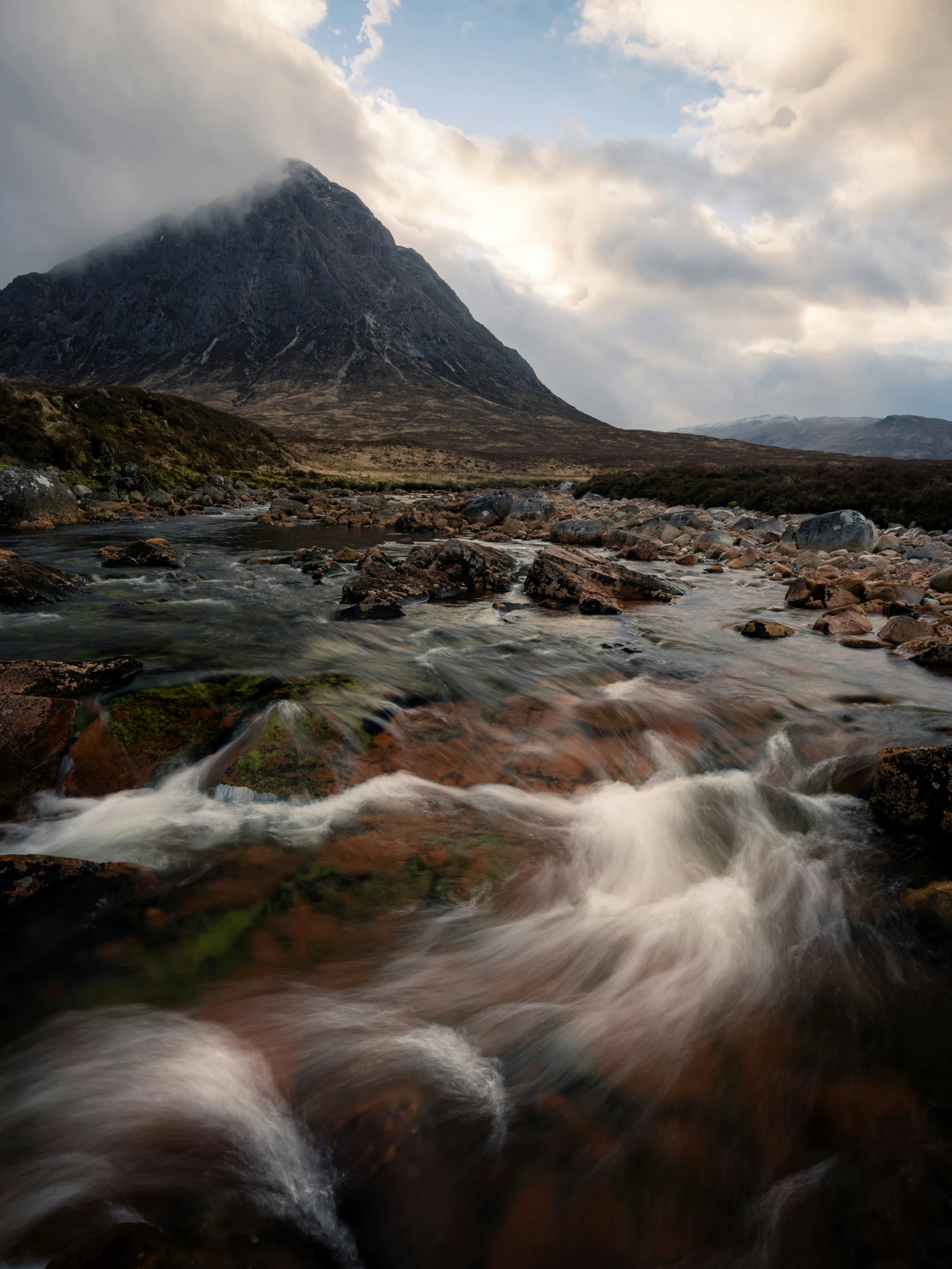 a mountain is in the distance with water running over it