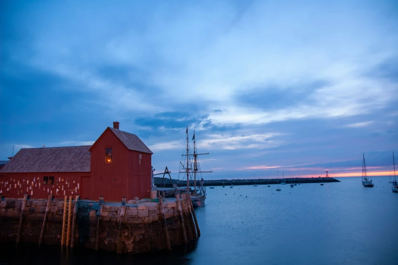 a harbor with a boat docked to it and a small red building