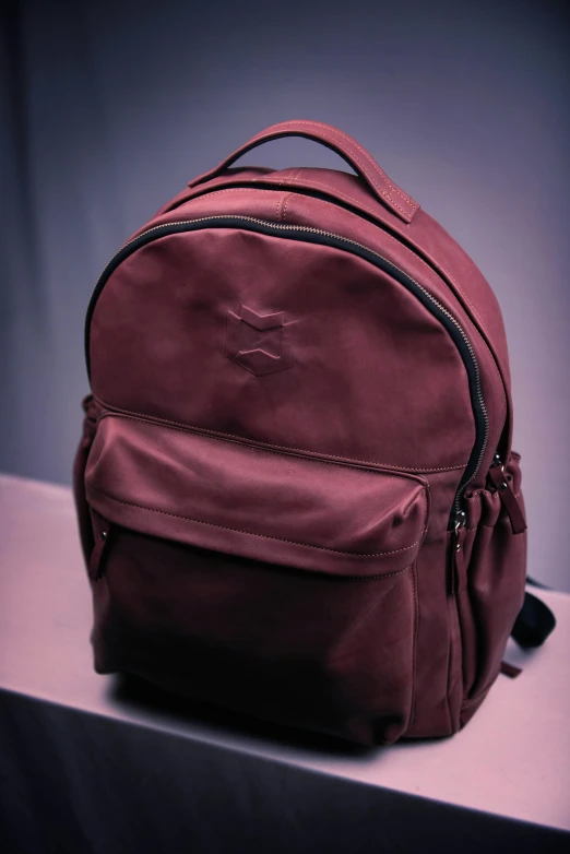 a maroon backpack sits on a counter top