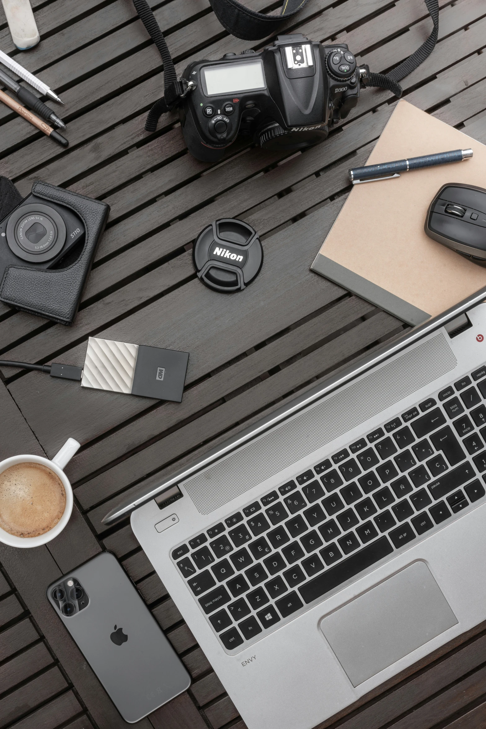 a camera, laptop and coffee on the ground