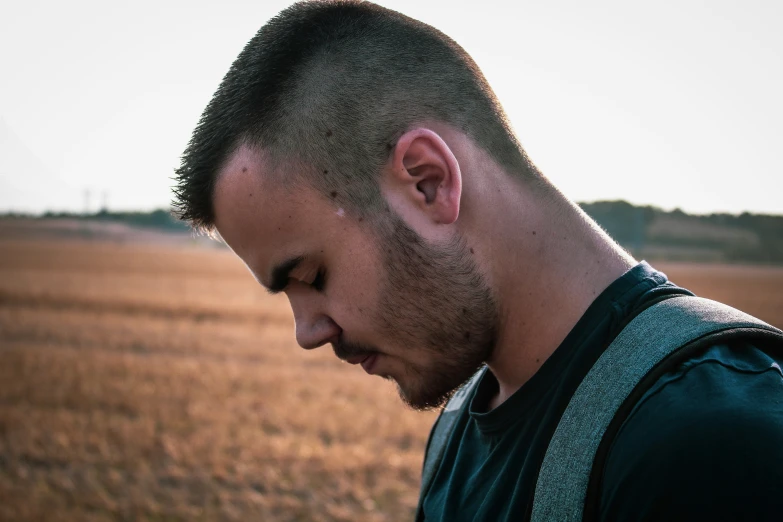 a man standing in an empty field looking down