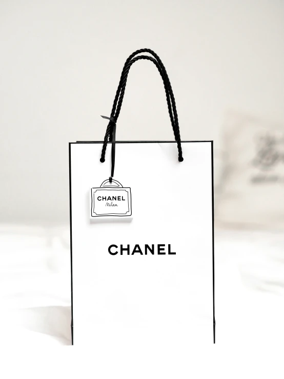 a white handbag with the word chanel written on it