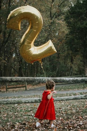 a little girl holding onto a large balloon