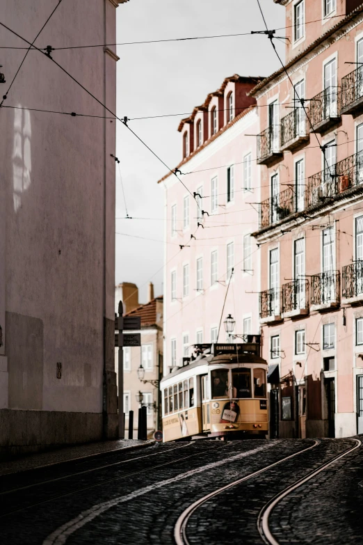 this is an old trolley on the tracks near a large building