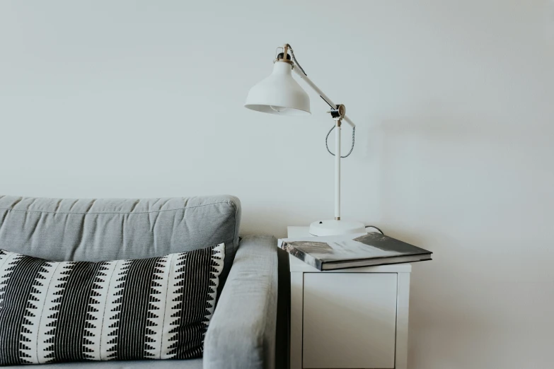 a couch with a light sitting next to it on top of a shelf