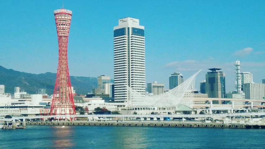 a city view of a tall building on the side of a river