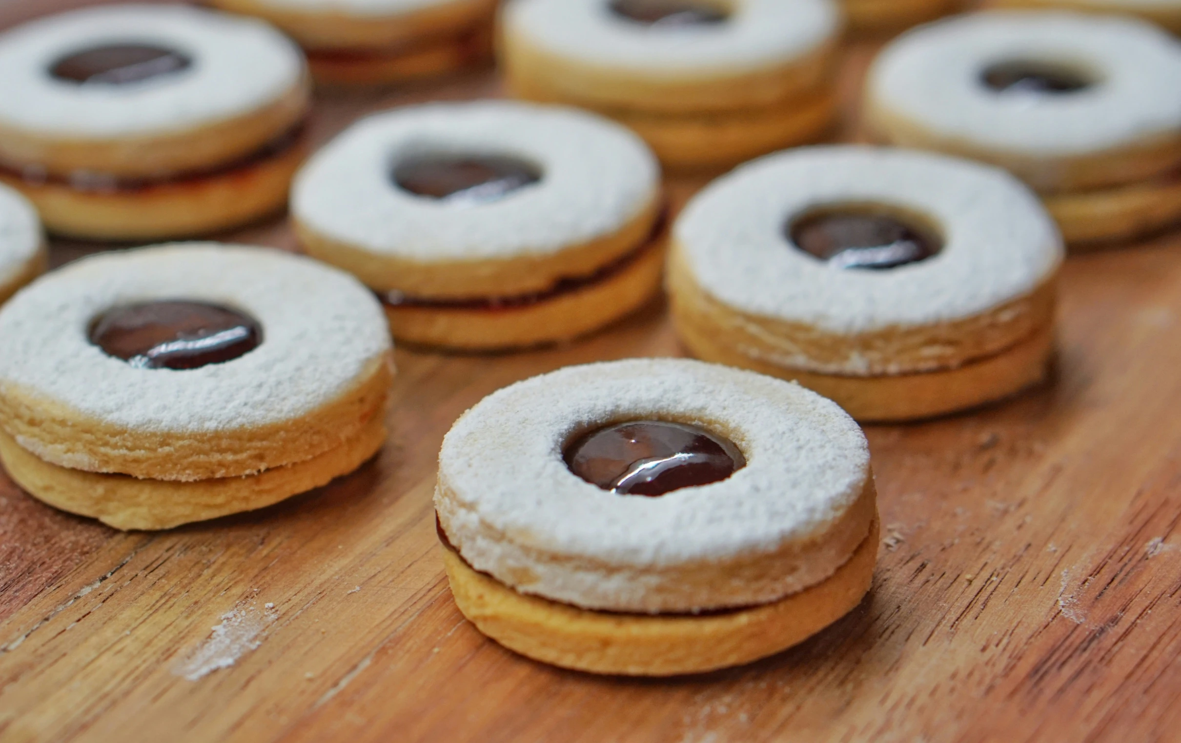 small chocolate donuts are on a wooden  board