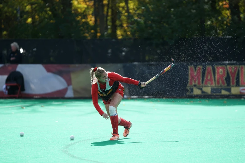 a woman in red and black outfit holding a stick