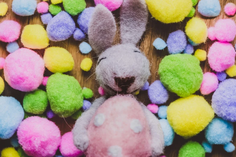 a toy bunny among easter eggs on a table