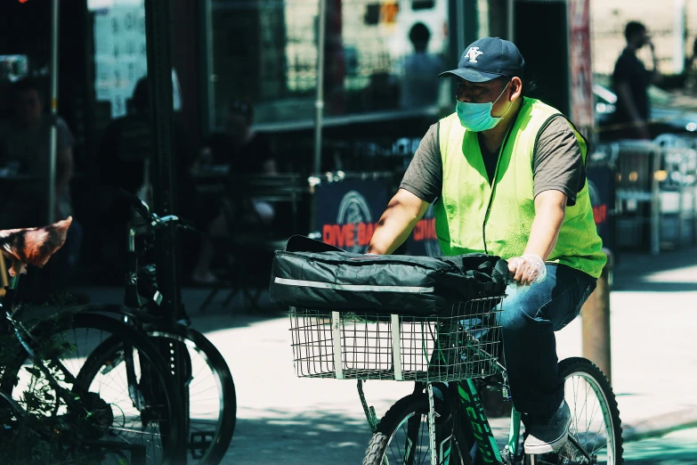 a man riding a bike down the road with a mask on
