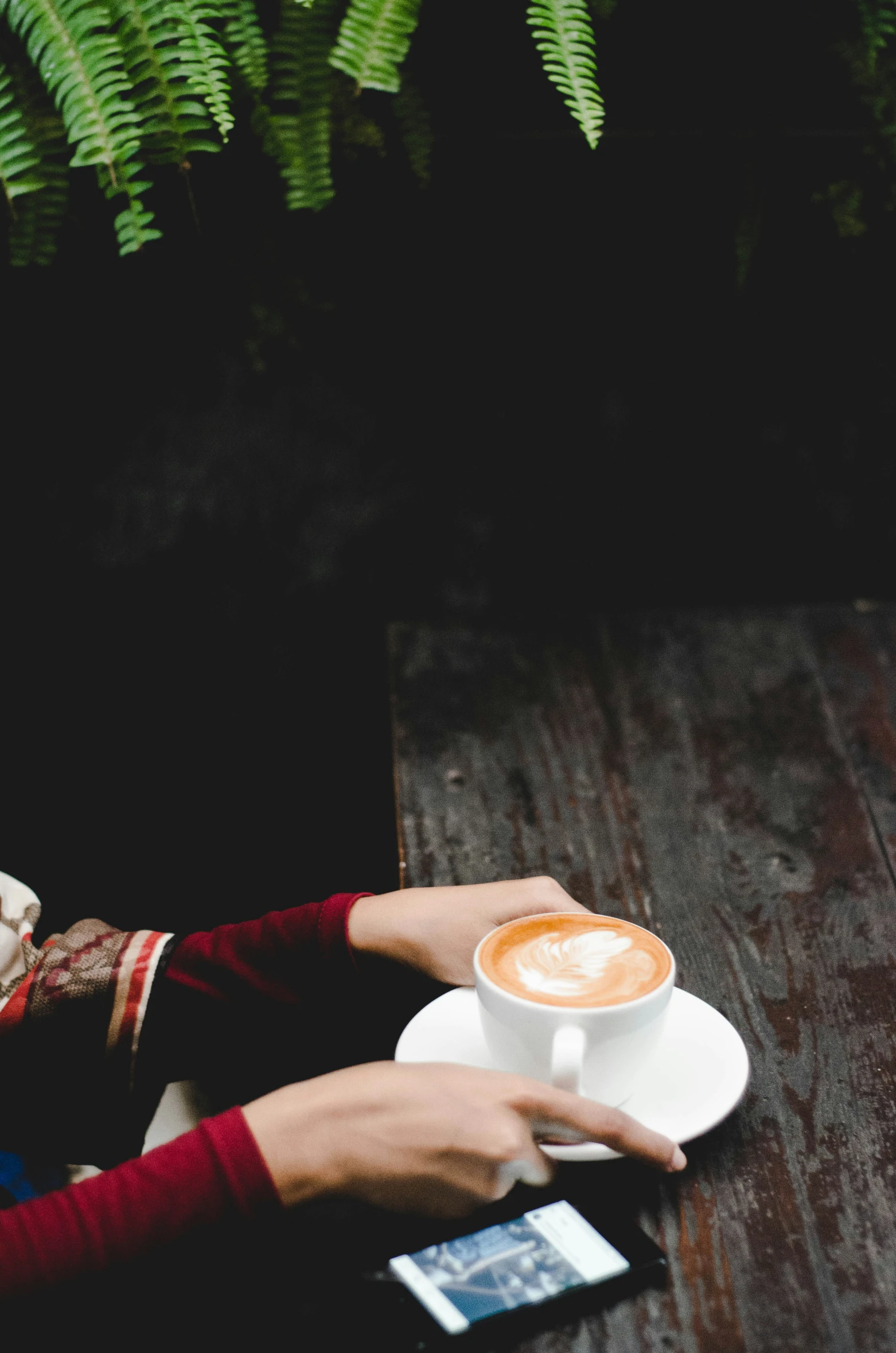 person holding a coffee mug in the middle of a table