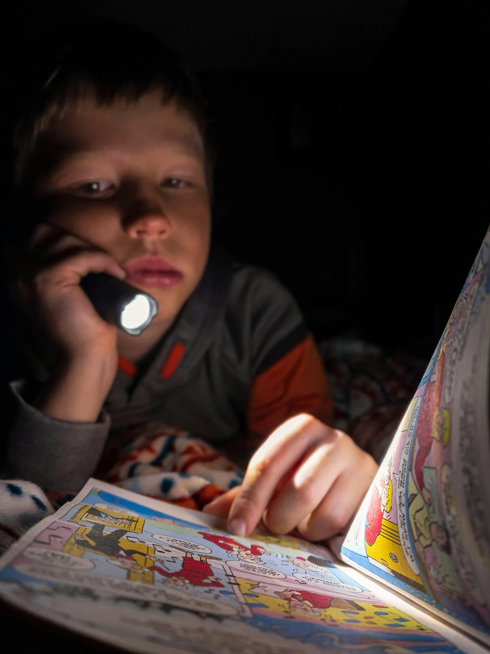 a  sits in bed and reads an electronic book