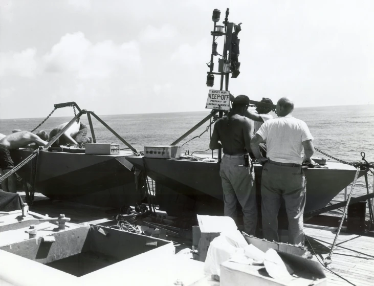 there are men standing on the deck of a boat