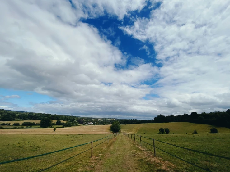 a picture of an empty grassy field with clouds in the background