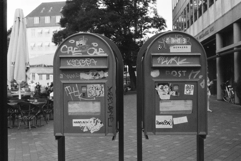 black and white po of two mailboxes with graffiti written on them