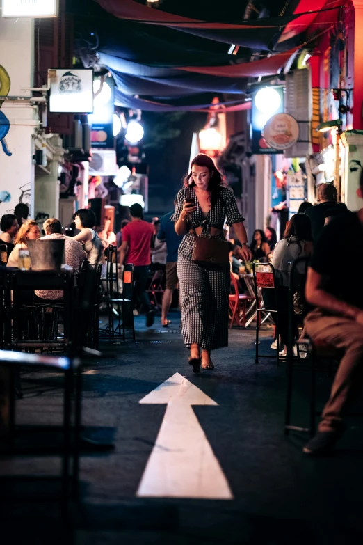 the woman is walking through an outdoor restaurant