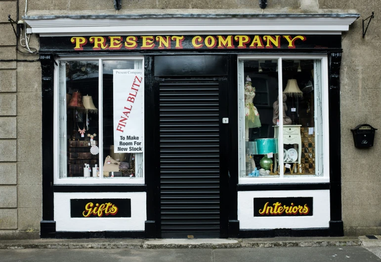 an old fashioned shop with a clock on the front of it