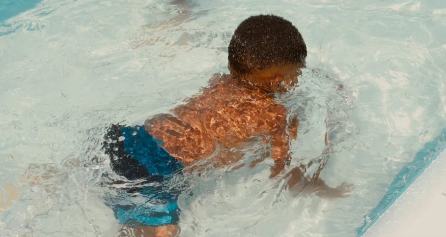 a young child swimming in a swimming pool