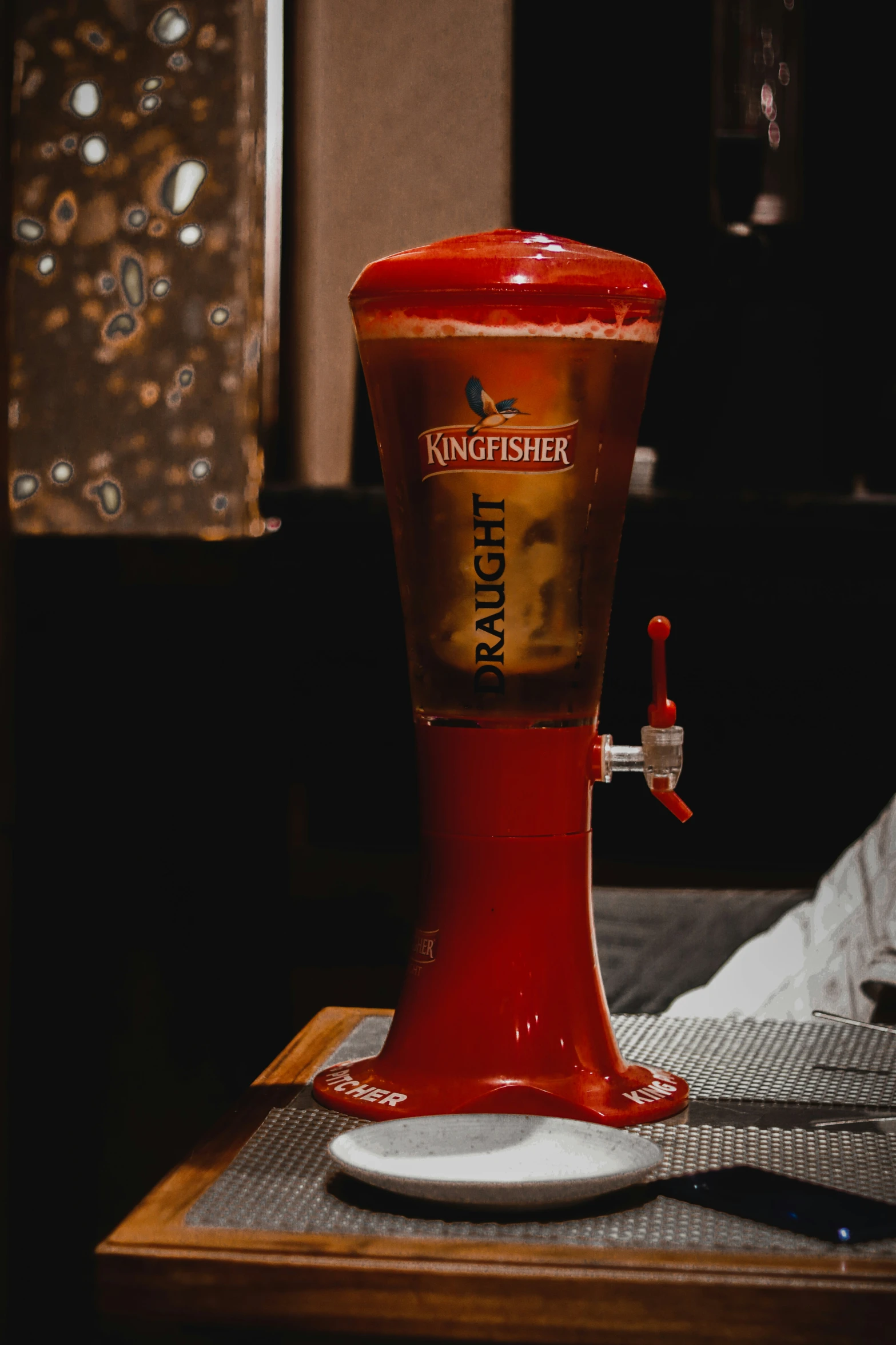 a soda fountain filled with liquid sitting on top of a table