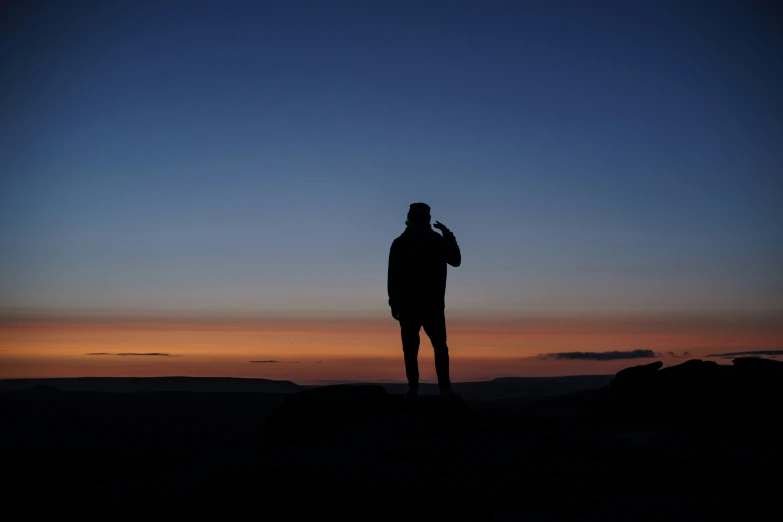 a person standing on a rock with a cellphone