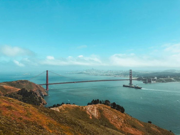 a view of the golden gate bridge from atop a hill