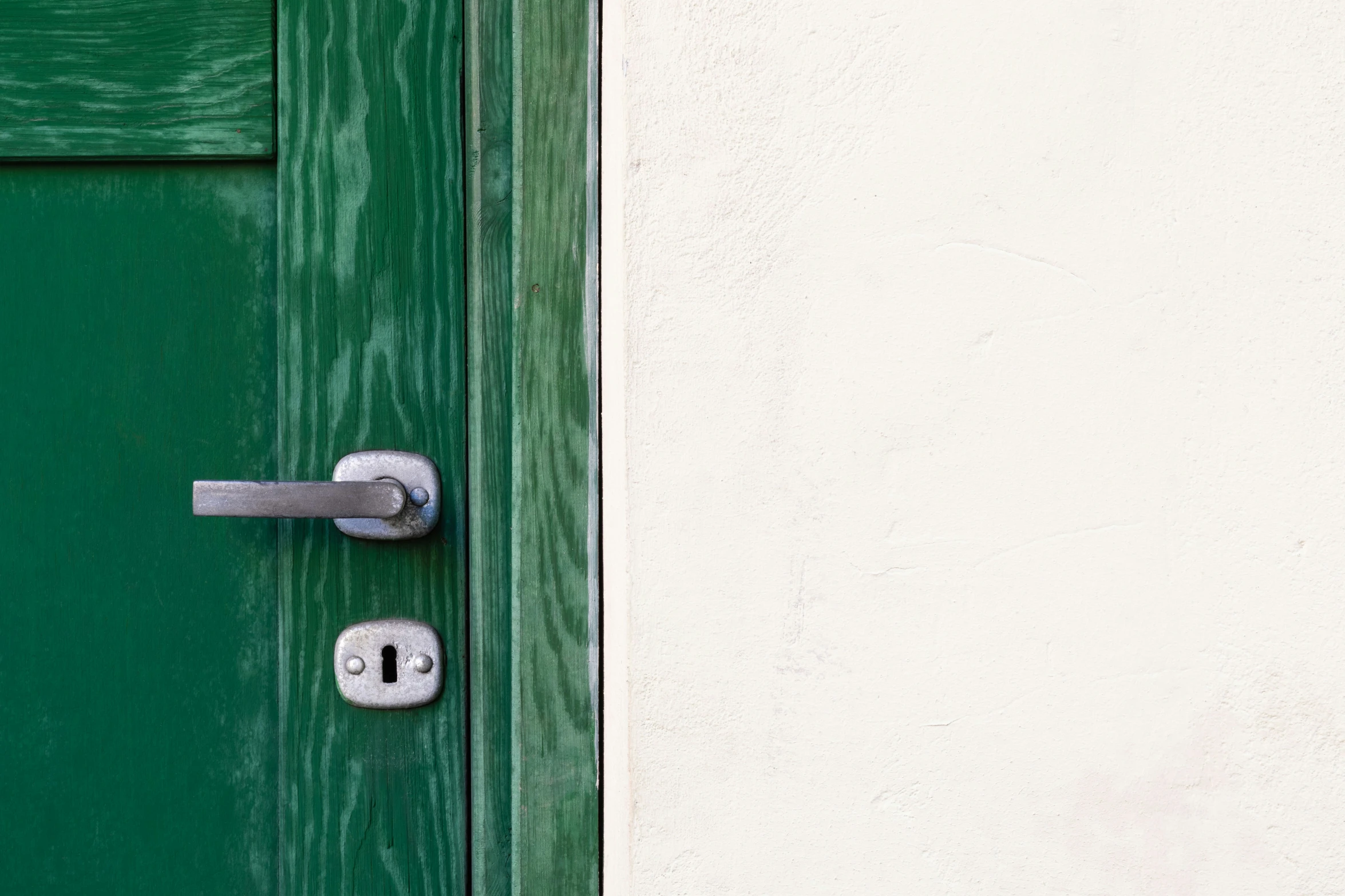 green and white door with a metal latch