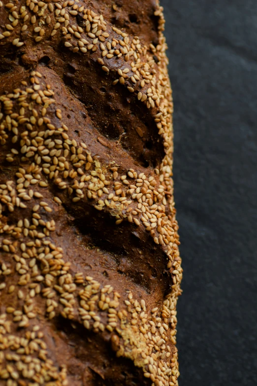 brown bread topped with sprinkled seeds on top of black table