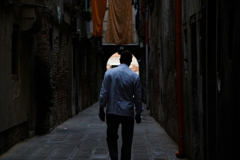 a man is standing in an alley between buildings