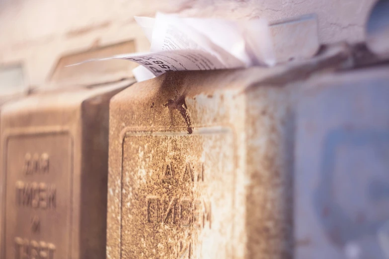 a couple of rusty mail boxes with mail coming out of them