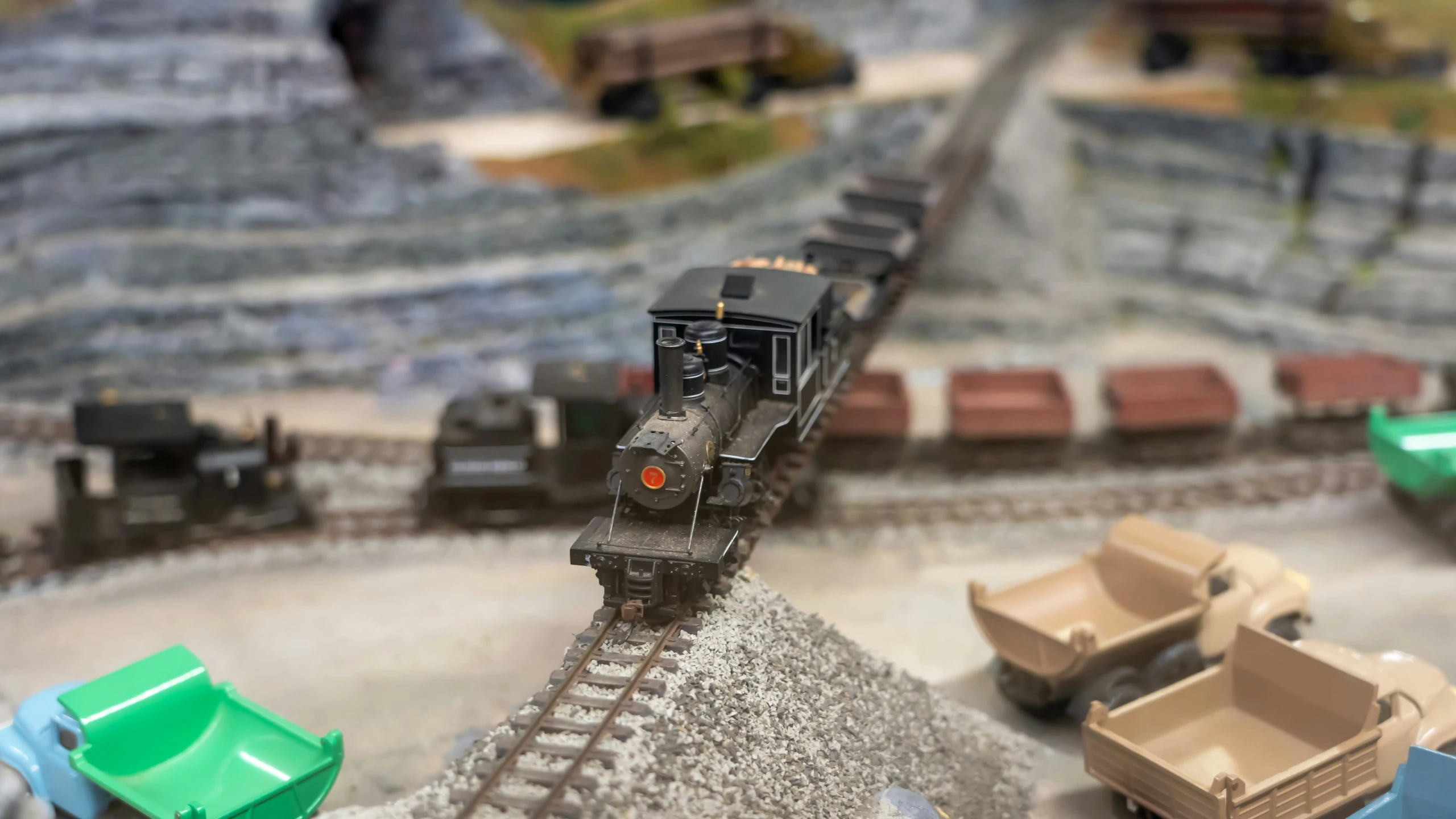 a toy model train is near a model train set