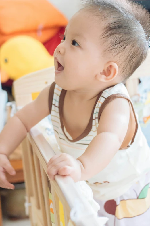 a baby smiles and hes the rails on her crib