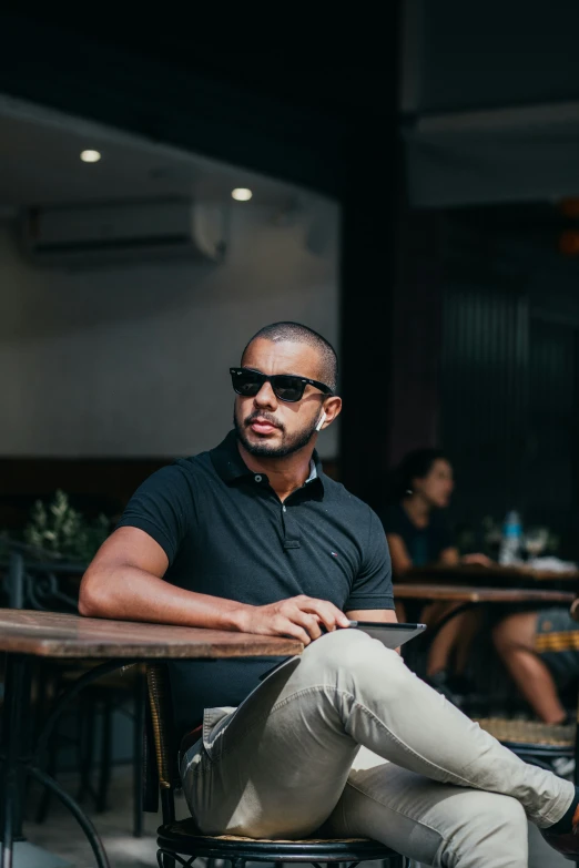 a man sitting at a table wearing sunglasses