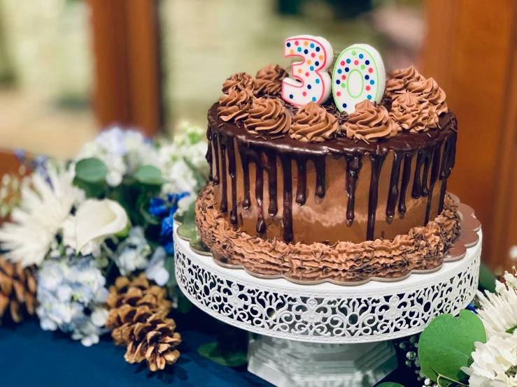 the decorated chocolate cake has two small candles on top of it