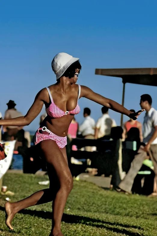 a black girl wearing a bikini and hat on the beach