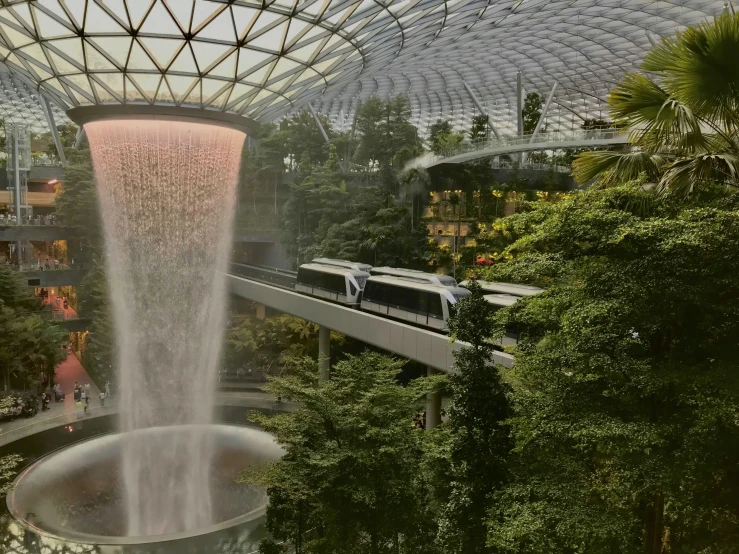 a train passes by water fountain at a shopping center