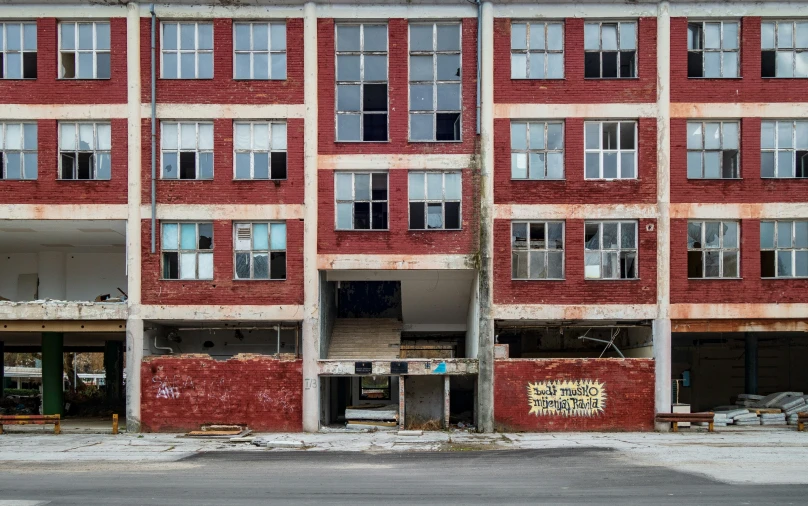 the building with several windows has boarded off, and graffiti on it