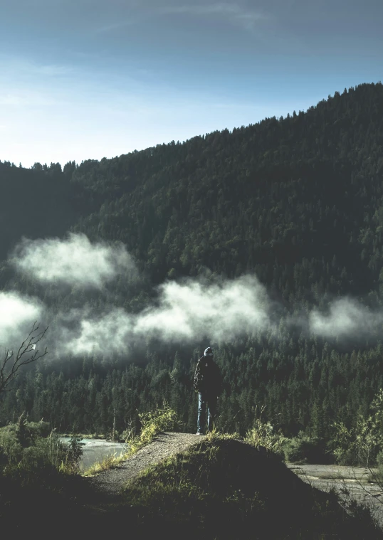 a man standing on top of a large hill