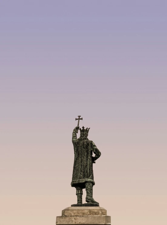 a statue with a cross on top with a sky background
