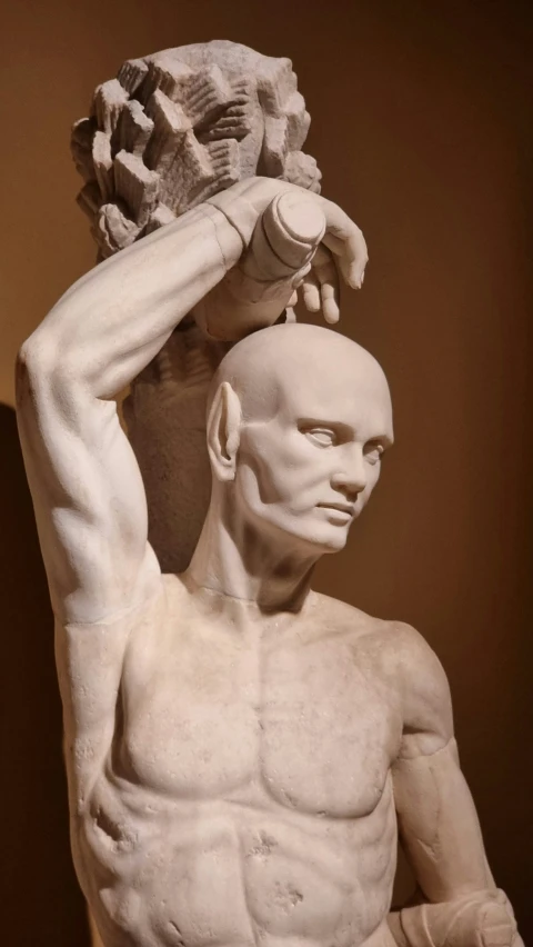 an old sculpture is holding his head up