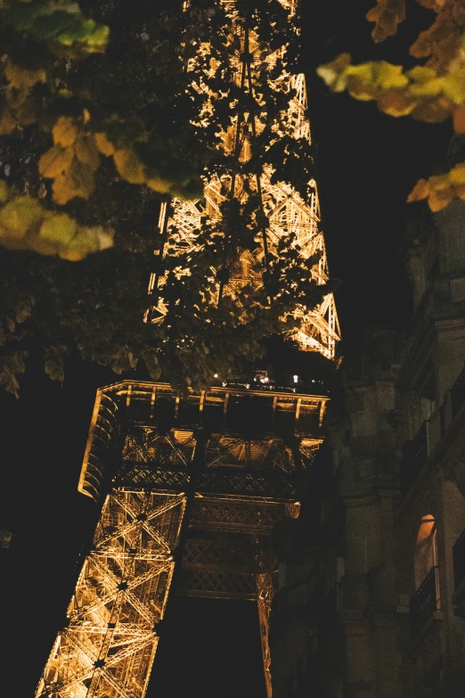 the top part of the eiffel tower is lit up at night