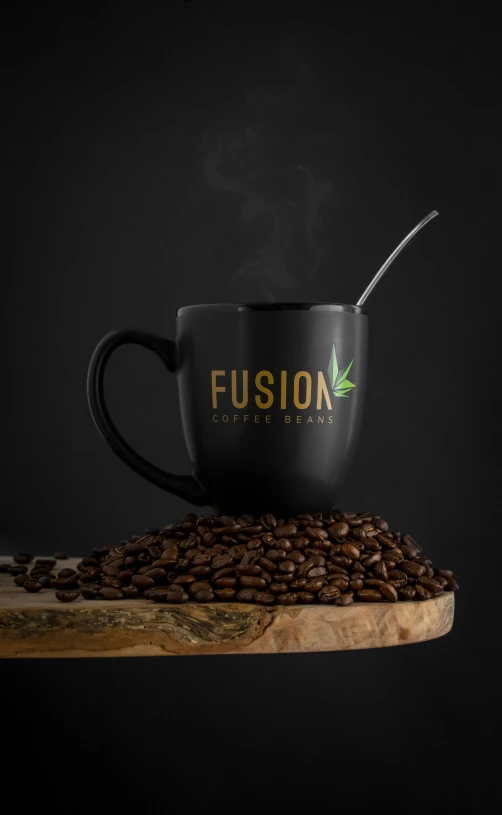 a black cup filled with coffee beans and a metal spoon