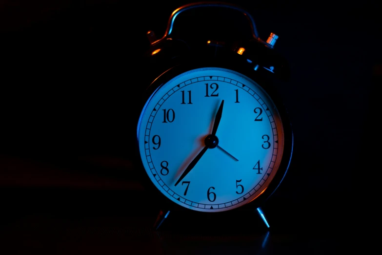 an alarm clock lit up in the dark