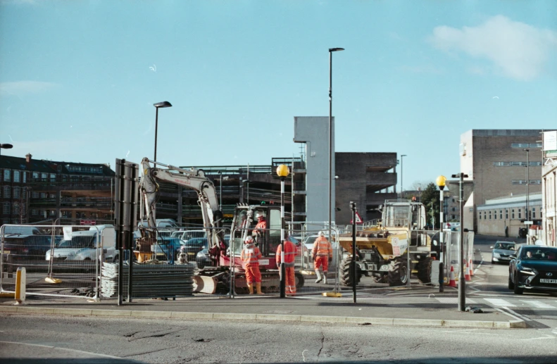 men in red work on street next to buildings