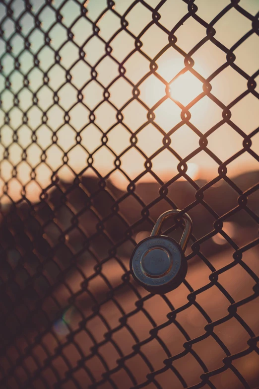 a golden chain link fence has a blue key on it