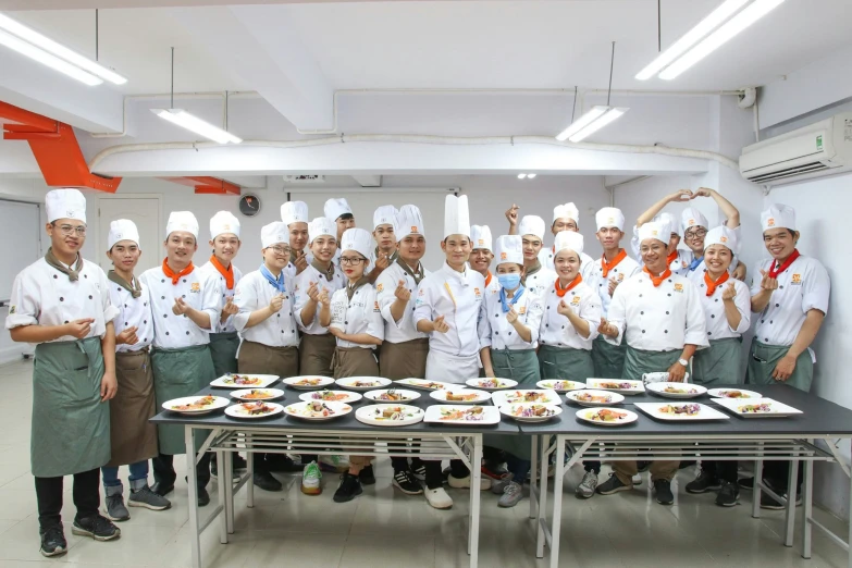 a group of people in chefs uniforms preparing food on plates