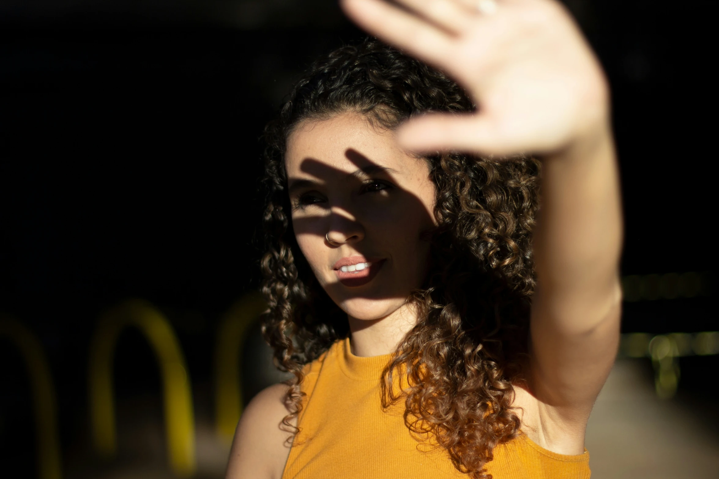 a woman in a yellow shirt waving at someone